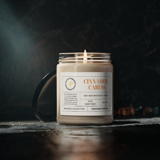 8 oz soy wax massage candle lit among dark backdrop. Cinnamon Caress: Allow this heady blend of fruit, vanilla & cinnamon along with mango butter, avocado & grape seed oil to transport you into your richest state of well-being.